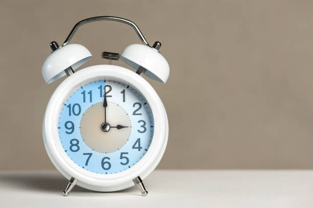 istock Three hours on the alarm. A white alarm clock is on a white table. The clock hand points to 3 o'clock. Time to change to summer or winter time. Set an alarm for 3:00 or 15:00. copy space 1411485065