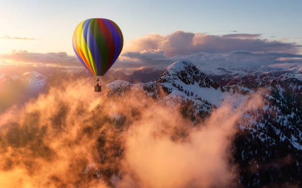 istock Dramatic Mountain Landscape covered in clouds and Hot Air Balloon Flying. 1411485161