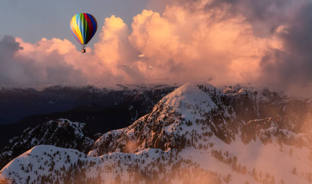 istock Dramatic Mountain Landscape covered in clouds and Hot Air Balloon Flying. 1411485176