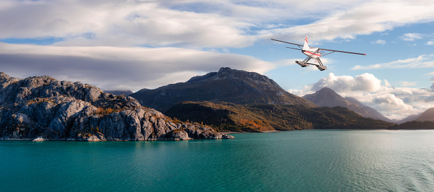 Seaplane Aircraft Flying over the Pacific Ocean Coast. Cloudy morning Colorful Sky.. 3d Rendering Adventure Dream Concept Artwork. Background Nature Image from Glacier Bay National Park, Alaska.