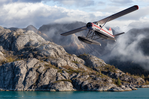 Seaplane Aircraft Flying over the Pacific Ocean Coast. Cloudy morning Colorful Sky. 3d Rendering Adventure Dream Concept Artwork. Background Nature Image from Glacier Bay National Park, Alaska.