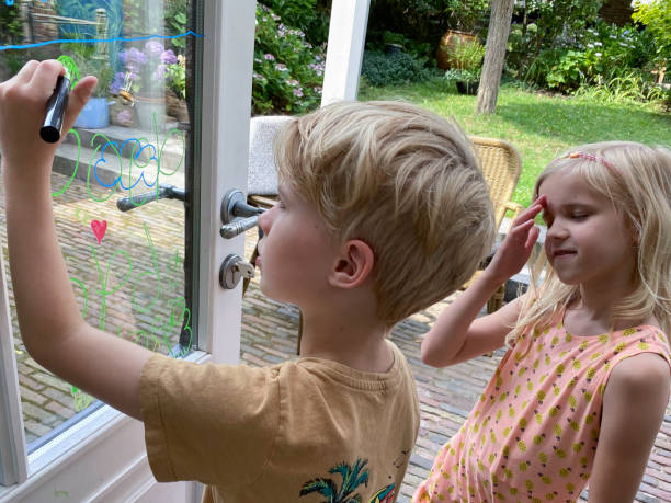 istock Brother and sister children making a window paint 1411486355