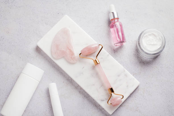istock Facial roller, gua sha, serum and moisturizing cream on marble background 1411486493