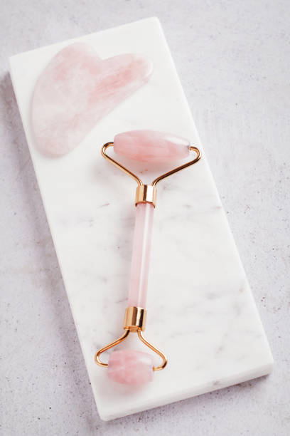 istock Facial roller, gua sha on marble podium, top view 1411486501