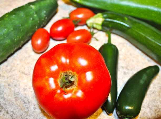 Dramatic and Delicious Farmer's Fresh Picked Produce Art for Website, Gardening Blog, Engaging Marketing Photos - Close Up Jalapeno Peppers, Fresh Zucchini, Cherry Tomatoes, Homegrown Cucumber, and Nice Sandwich Slicer Tomato Just Picked From our Garden - Healthy Organic Produce - Close Up View of Wonderful Ingredients for Tonight's Family Supper picked by Mom - Beautiful Fresh Garden Crop on the Kitchen Counter - Fresh Produce Background Art Images for Effective Engagement with Your Customers - Freshest Menu Art fotografía libre de derechos - productos frescos del huerto - las mejores golosinas de jardín recién recogidas - tomates, jalapeños, calabacines y pepinos - mejor fondo de productos frescos de granja para sitio web, blog de jardinería, imágenes de ma