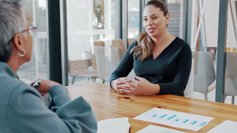 Woman doing an interview with an HR manager in an office. Female talking to a hiring recruiter at a potential workplace. Businesswomen having a meeting and discussing a partnership.