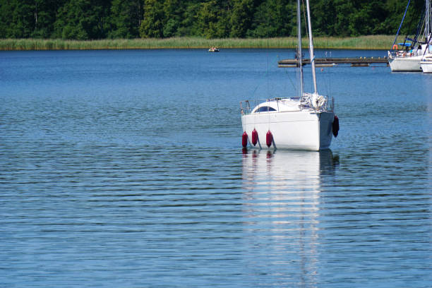 istock Sailboat and it's reflection in lake 1411490380