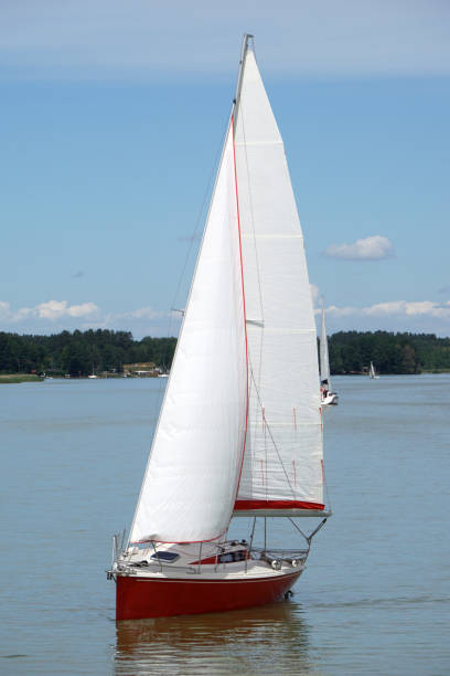 istock Red sailboat swimming on a lake 1411490497