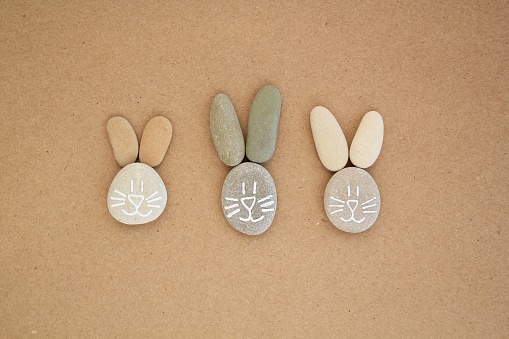 Bunny faces from pebbles on craft paper background