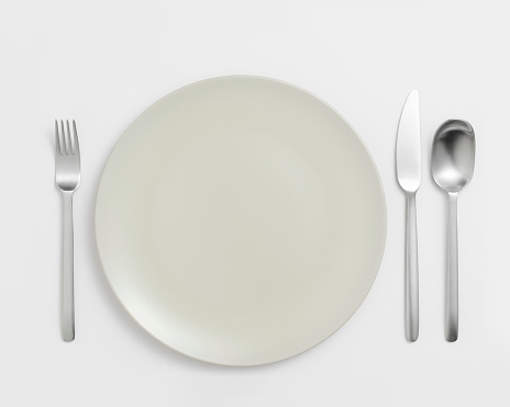 Plate and set of cutlery on white background