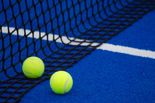 블루 패들 테니스 코트, 그물 근처의 두 개의 공 - tennis artificial turf playing field sports venue 뉴스 사진 이미지