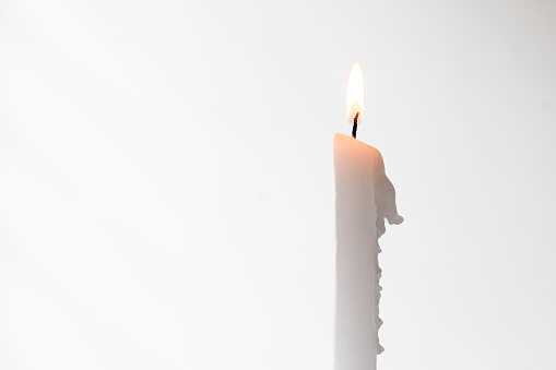 Front view of white candles with flame with white background