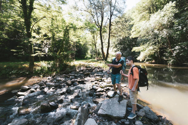 istock Happy grandfather and grandson crossing a river 1411494939