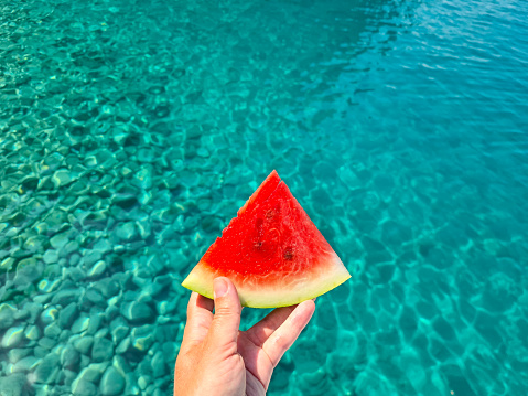 Bright red watermelon on blue sea background. Summer vocation concept.