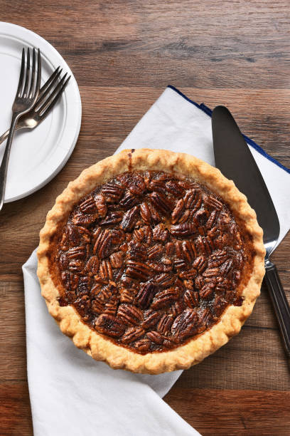 istock A fresh baked Pecan pie with server, plates and forks. The dessert is part of a typical Thanksgiving Day Feast. 1411509363