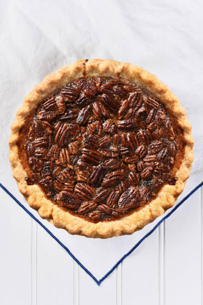 istock High angle view of a fresh baked Pecan pie on a white kitchen towel, Vertical format. 1411509664