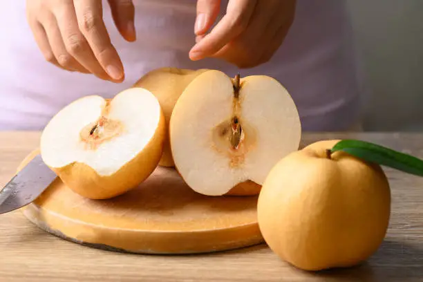 Photo of Asian pear or Nashi pear cutting on wooden board