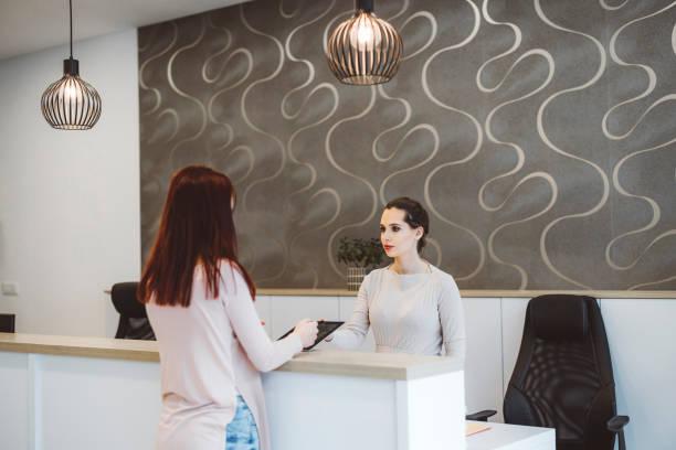 istock Receptionist greeting a client at car rental agency 1411516356