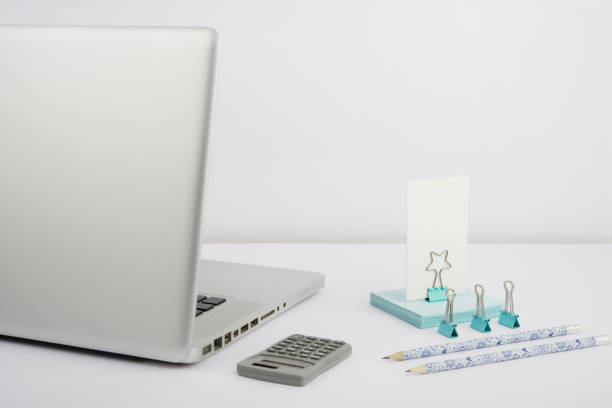 Lap Top, Pencils, Calculator, Paperclips And Sticky Notes Placed On Desk.