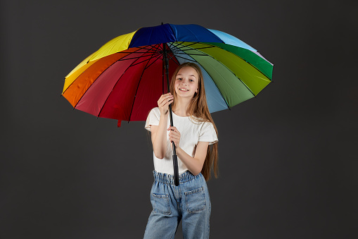 Beautiful smiling teenage girl with a colorful umbrella.