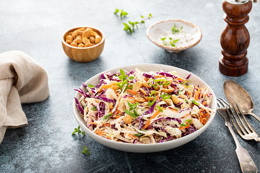 Asian cabbage cole slaw with peanut sauce, roasted peanuts and green onions