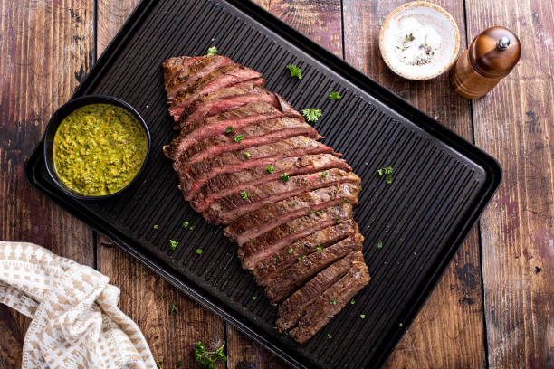 Grilled flank steak with chimichurri sauce on a grill pan stock photo
