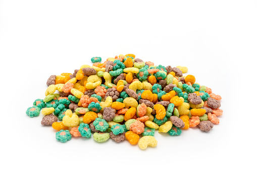 Multicolor corn puffs cereals on white background.