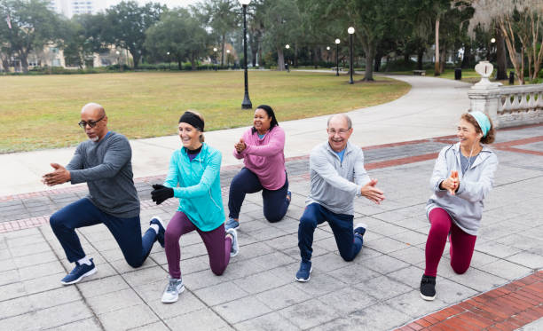 istock Five multiracial adults stretch in park, kneeling lunges 1411532874