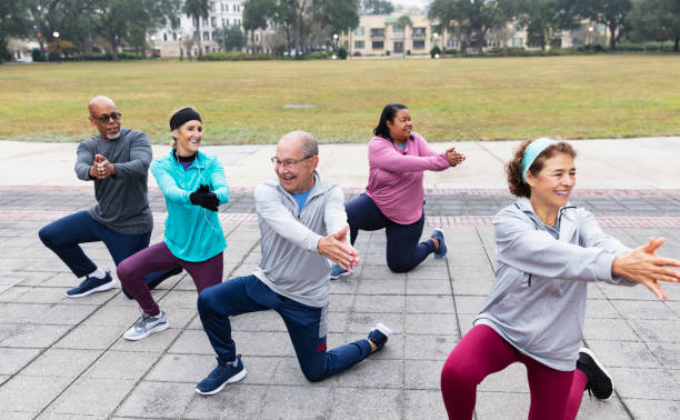 istock Five multiracial adults stretch in park, kneeling lunges 1411532929