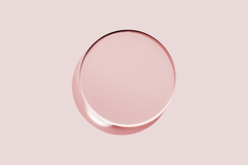 Empty round petri dish or glass slide on pink background. Mockup for cosmetic or scientific product sample.