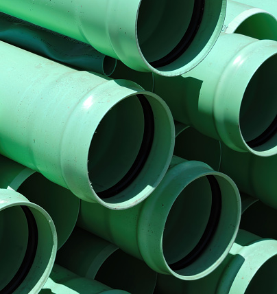 Close up of a stack green plastic industrial water pipes.