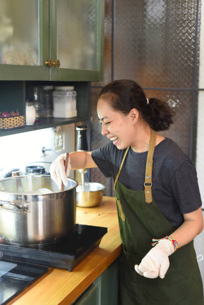 istock Young Vietnamese woman mixing  dough for a cake 1411540907