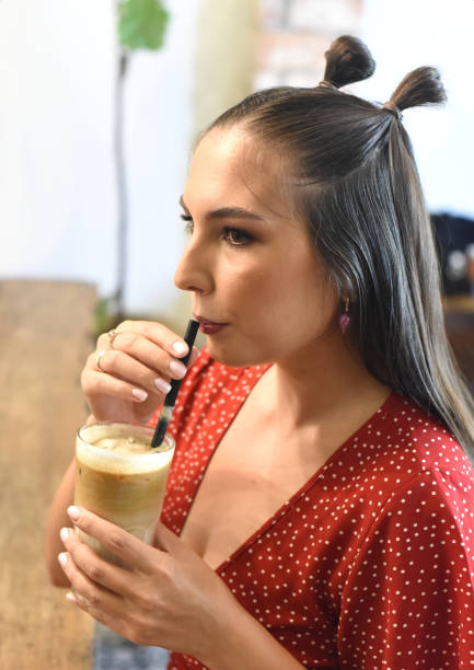 istock Young woman  drinking ice coffee in a coffee shop 1411540930