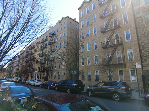 A row of brownstones in Brooklyn, New York. One blue row home and the rest are red.