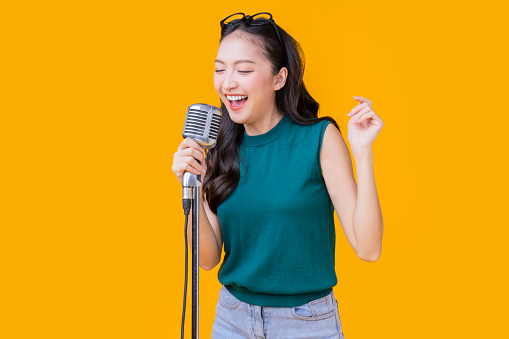 happiness carefree asian young female woman teen wearing headphone smartphone listen music joyful fun moving moment ,teen wear casual cloth singing move while laugh smile trendy lifestyle studio shot
