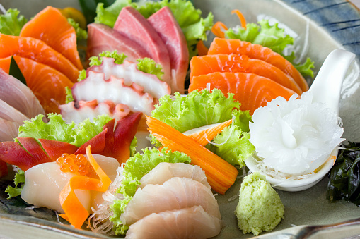 Sashimi mori, mix sashimi set served in ceramic plate decorated with green lettuce. Japanese Cuisine Buffet. Chef's Choice: Salmon, hamachi, Ika, Tako, Hotate and hokkigai