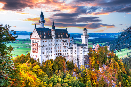 Neuschwanstein, Bavaria - October 2021: Famous Schloss Neuschwanstein Castle, Germany in beautiful autumn colors in Fussen province, Bavarian Alps.