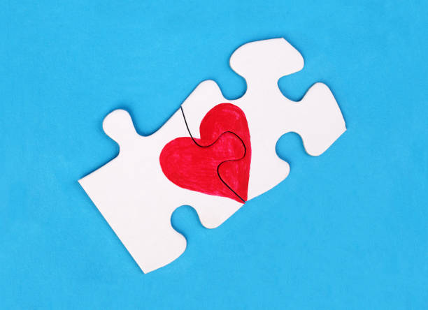 istock Pieces of a puzzle forming a heart on blue background 1411550806