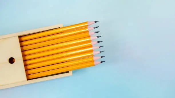 Photo of Set of simple pencils in wooden pencil case. pencils in wooden box. Back to School concept, top view