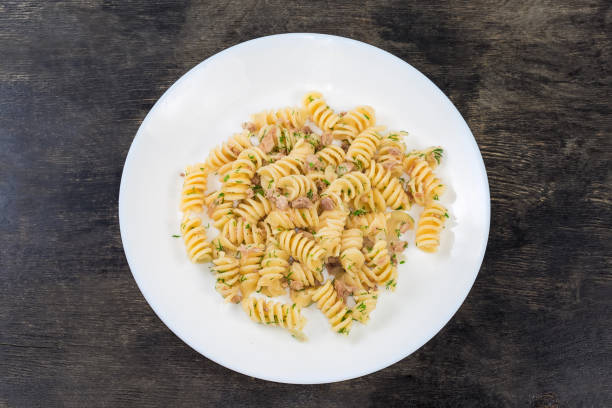 istock Prepared spiral pasta with chopped meat and dill on dish 1411559964