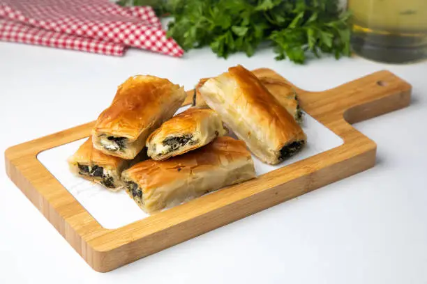 Traditional delicious Turkish food; Handmade Spinach Cheese Pie - pastry, Turkish name; el acmasi borek, rulo borek. Turkish borek rolls with spinach and cheese. A traditional Turkish pastry rulo borek