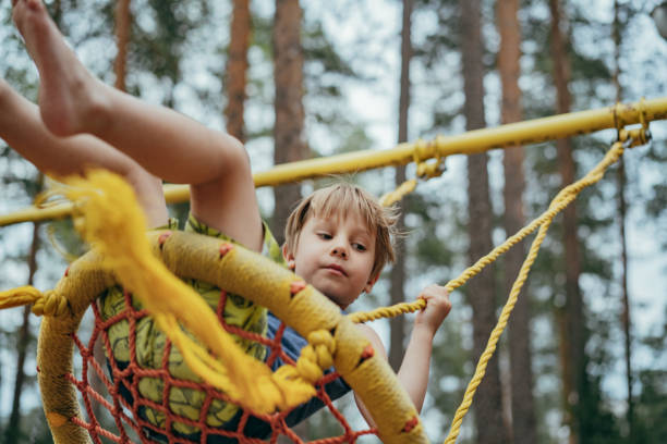 istock cute little boy having fun on a swing at playground 1411563199