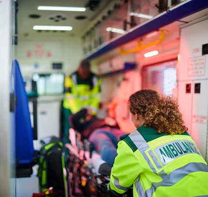 ambulance paramedics with casualty inside ambulance