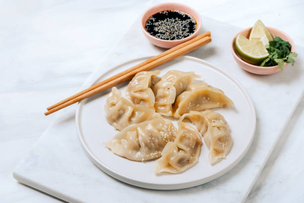 istock Gyoza dumplings  on a white plate with soy sauce 1411566052