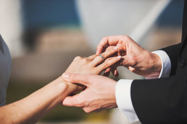 istock Bride and groom exchange rings at the wedding ceremony 1411566917