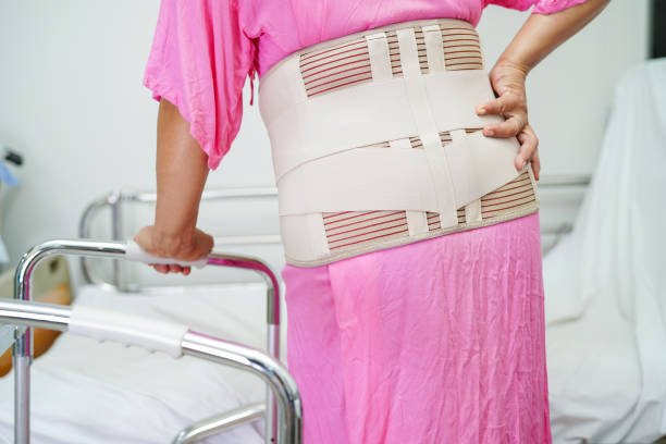 istock Asian senior pain back wearing elastic support belt with walker. 1411567422