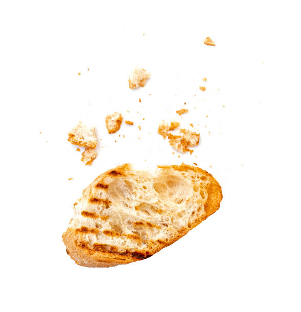 pezzo di pane bianco secco bruschetta o baguette con briciole isolate su bianco - pangrattato foto e immagini stock