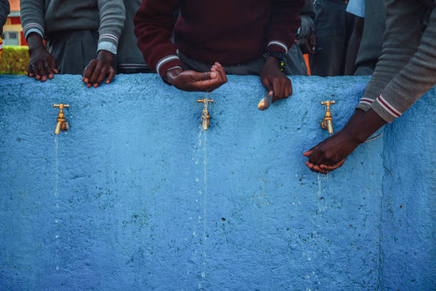 아프리카에서 물의 부족. 아프리카 어린이들은 물줄기로 손을 잡고 있습니다. 일러스트 사진. 아프리카의 가뭄 - water drinking village rural scene 뉴스 사진 이미지