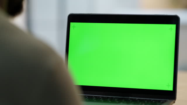 Closeup of laptop with a green screen copyspace. One unknown businessperson using technology in the office. Advertising, promoting and marketing for creative web design on chromakey computer monitor