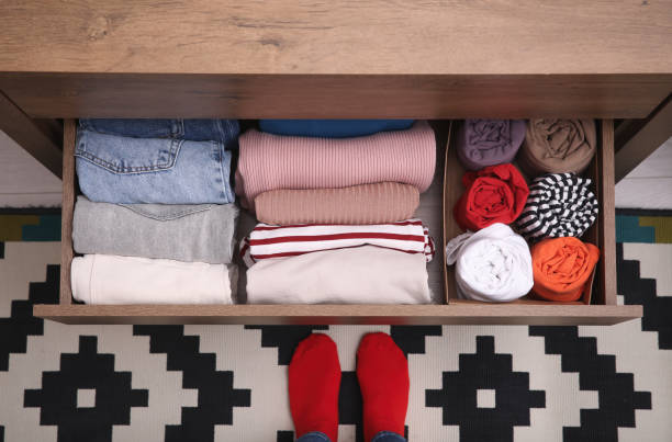 istock Woman near open drawer with folded clothes indoors, top view. Vertical storage 1411574249
